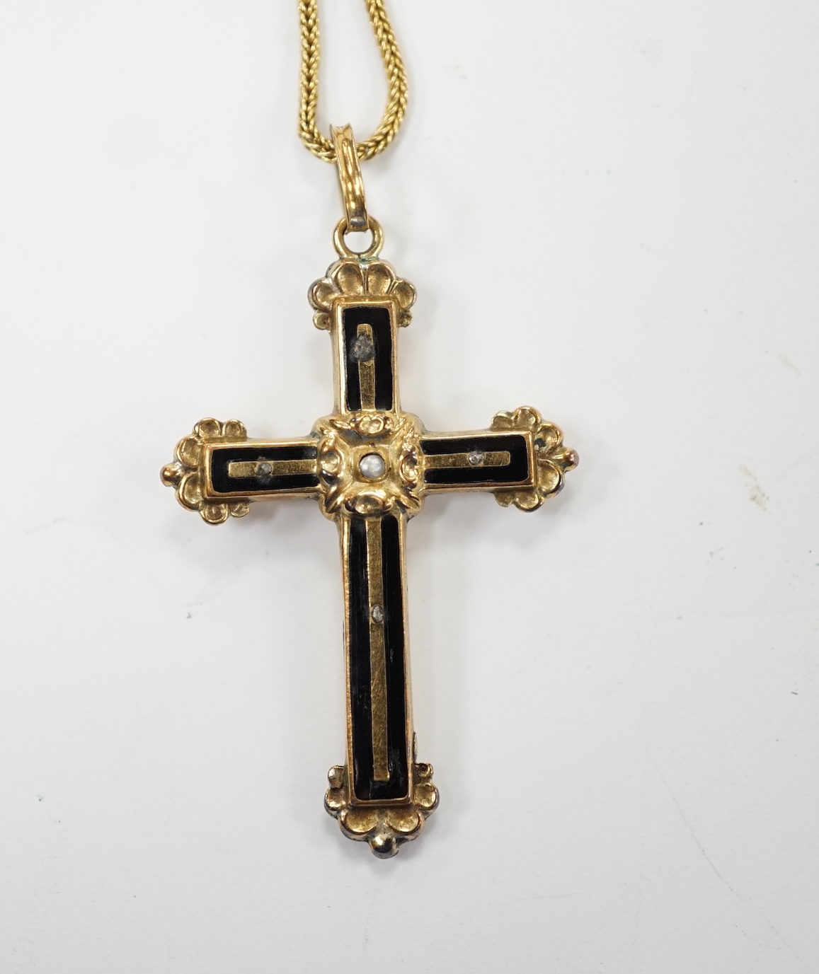 A yellow metal, black enamel and seed pearl set cross pendant, 30mm, on a yellow metal fine link chain, 38cm, gross weight 4.2 grams. Fair condition.